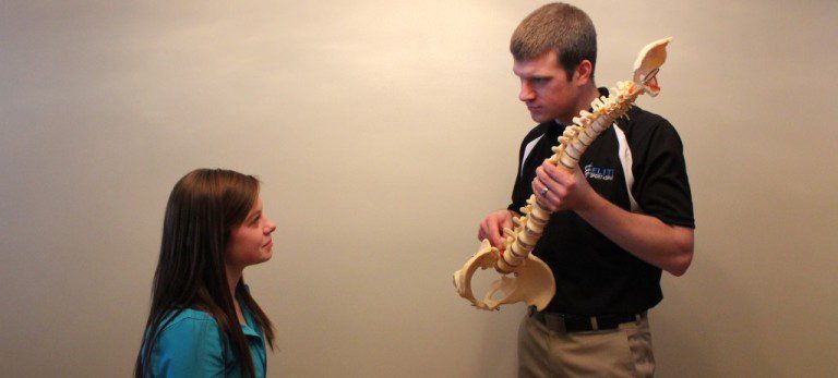 Zach explaining something about the spine to a patient