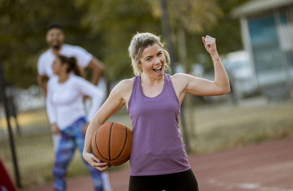 Woman with basketball ball playing game outdoors