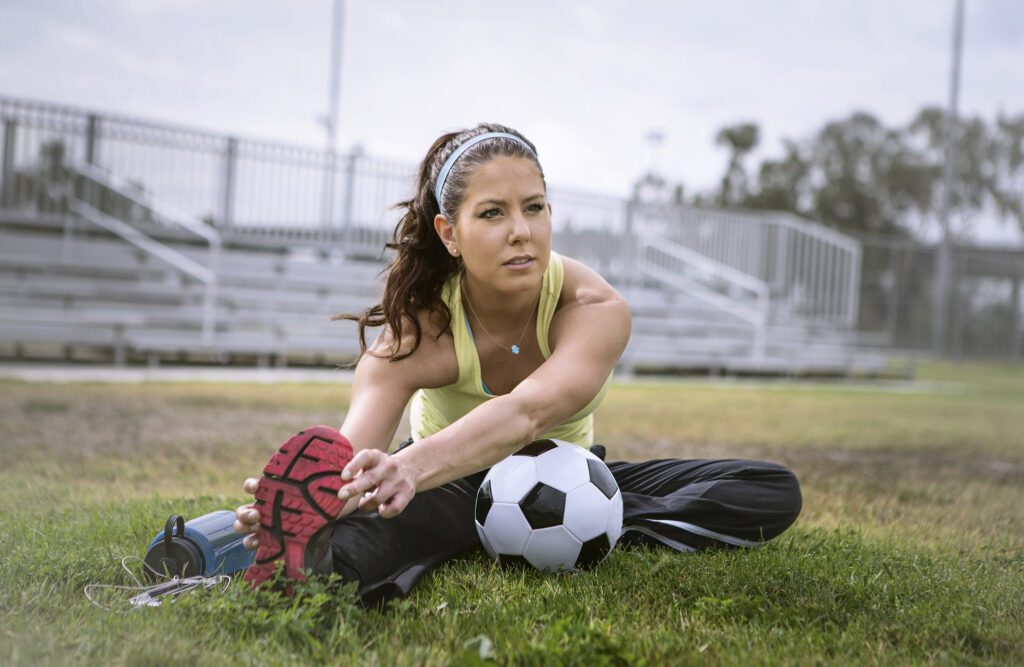 Soccer player stretching in a soccer field