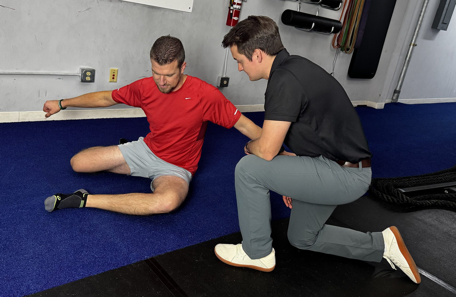 coach helping patient with hip exercise