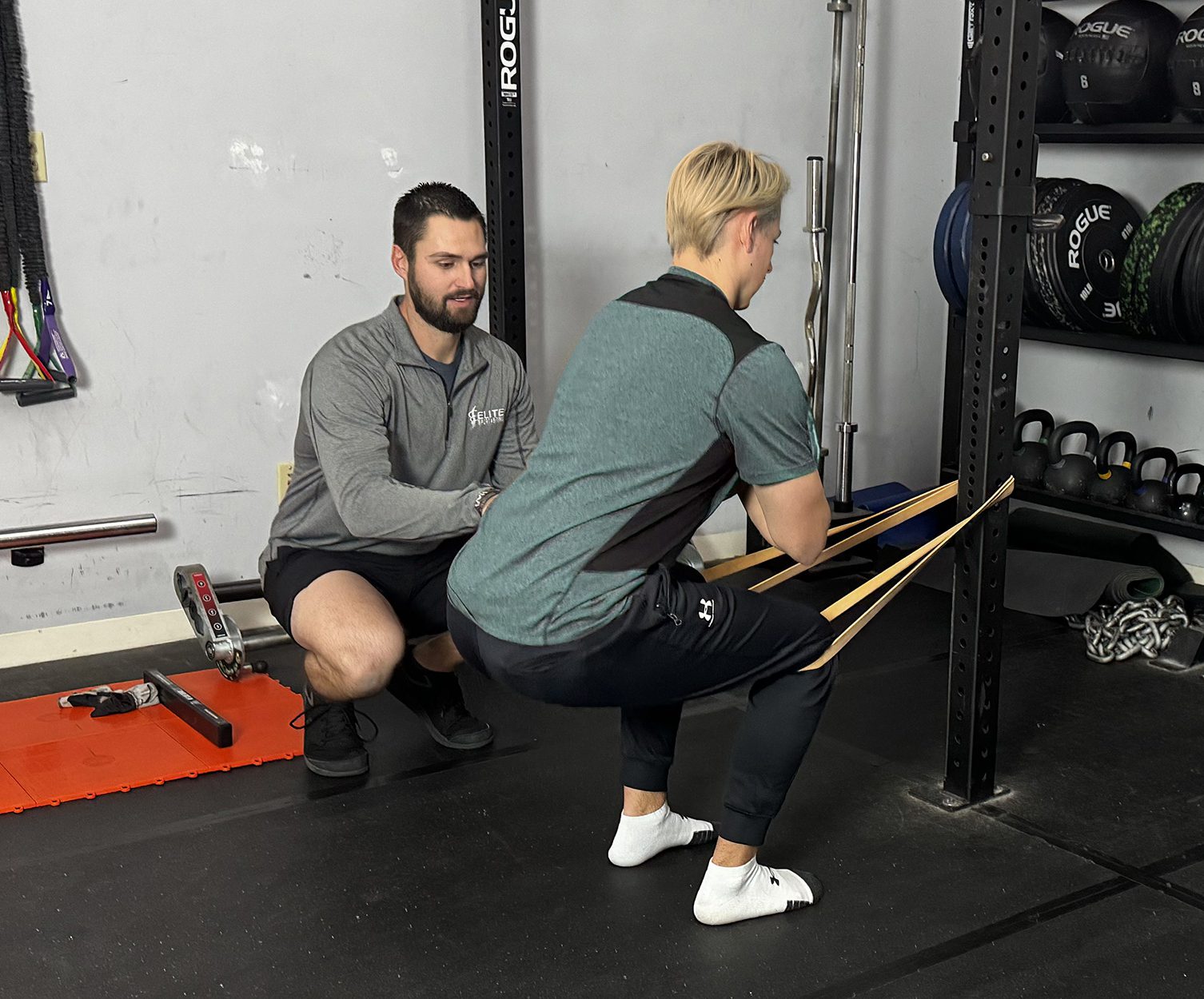 Tyler Koehler helping client with body weight squats